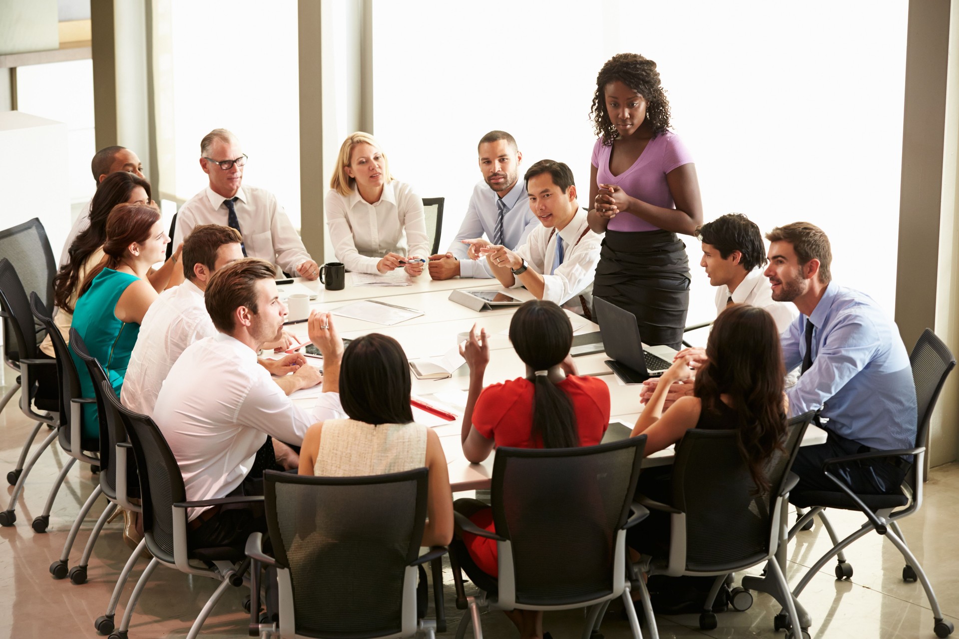 Businesswoman addressing others around board table